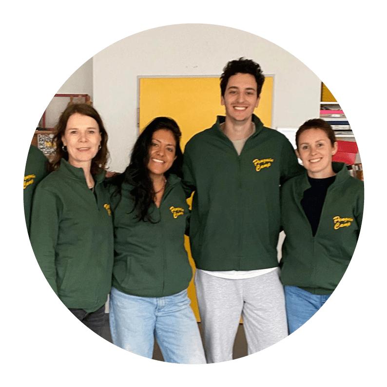 Drei Frauen und ein Mann im Penguin CAmp Blousons umarmen sich und lachen zum Betrachter