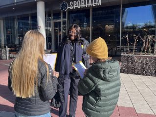 zwei Mädchen interviewen eine Piloton auf dem Flughafen